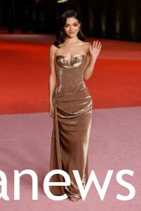 Rachel Zegler in a gold dress