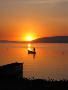Vibrant Sunset Colors Over Lake Victoria Fishing Boats:watch as the sun gets to fade down the slopes