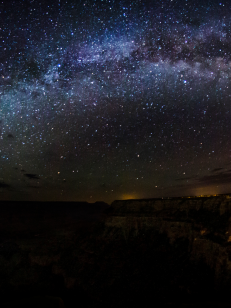 Volcanic peaks and ash cones providing stark, unique foregrounds against the stars.